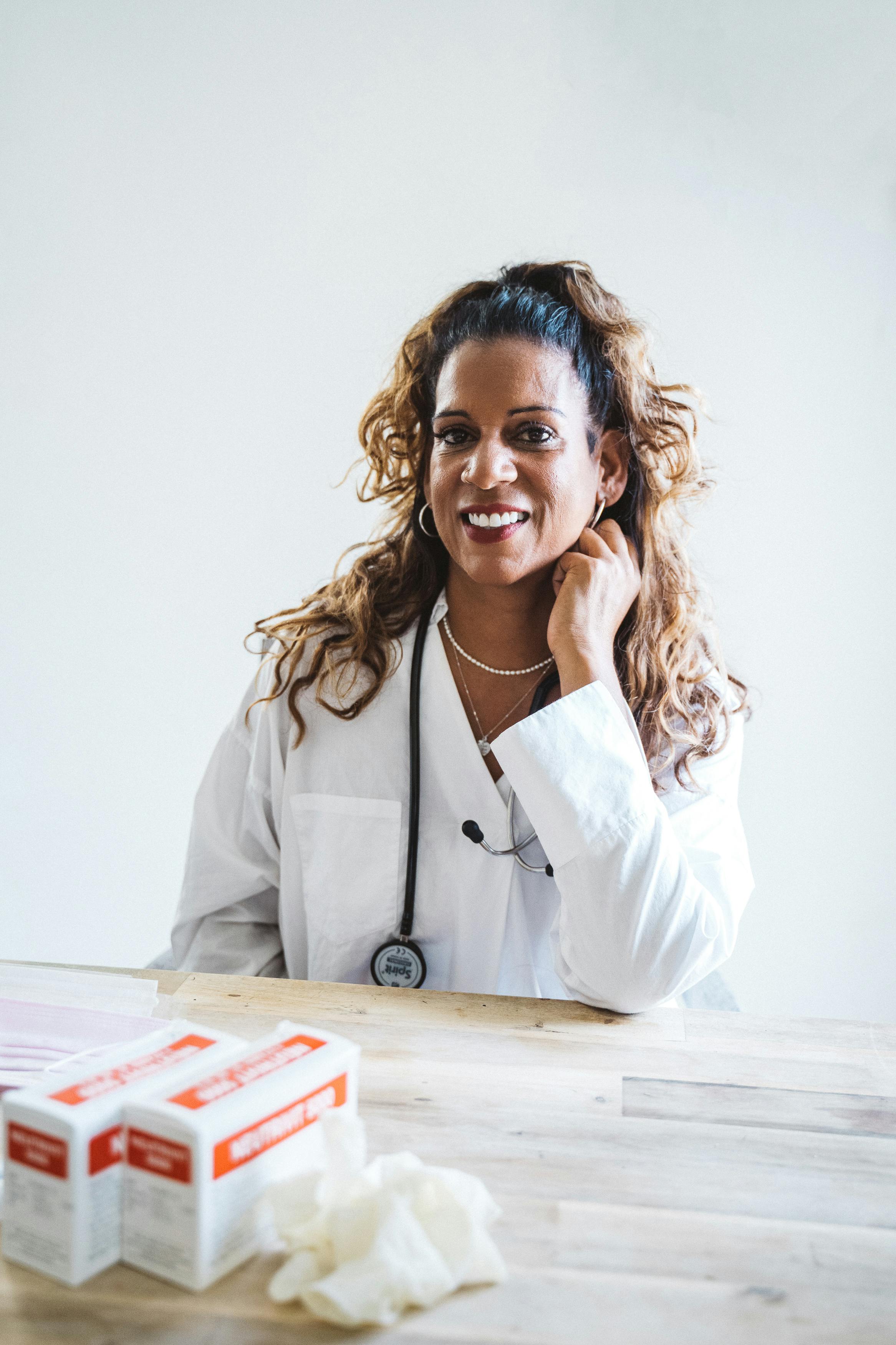 Smiling female doctor in a lab coat with a stethoscope, exemplifying healthcare expertise.