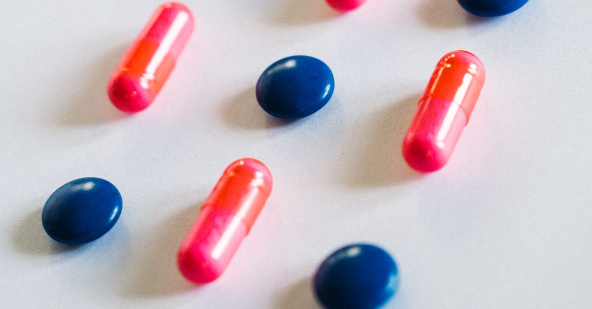 Pink and blue pills on a white surface