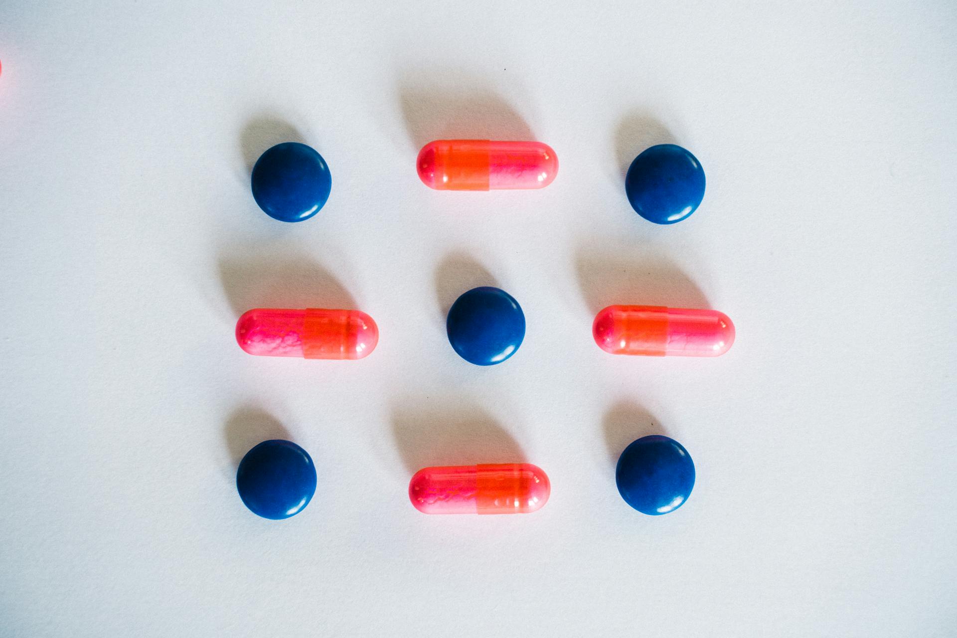 A Pink and Blue Medication Pills on White Surface