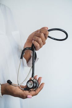 Close-up of a healthcare professional's hands holding a stethoscope, focusing on medical care.