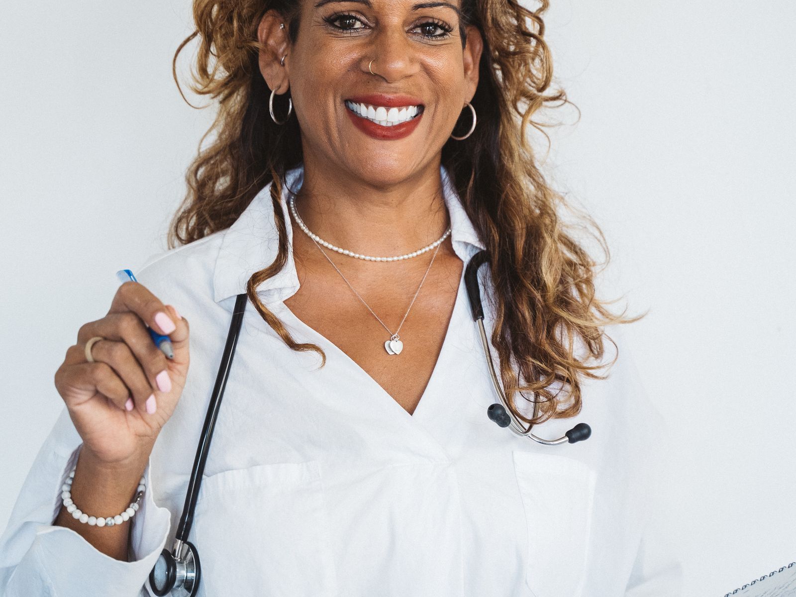 Smiling doctor holding a clipboard and stethoscope