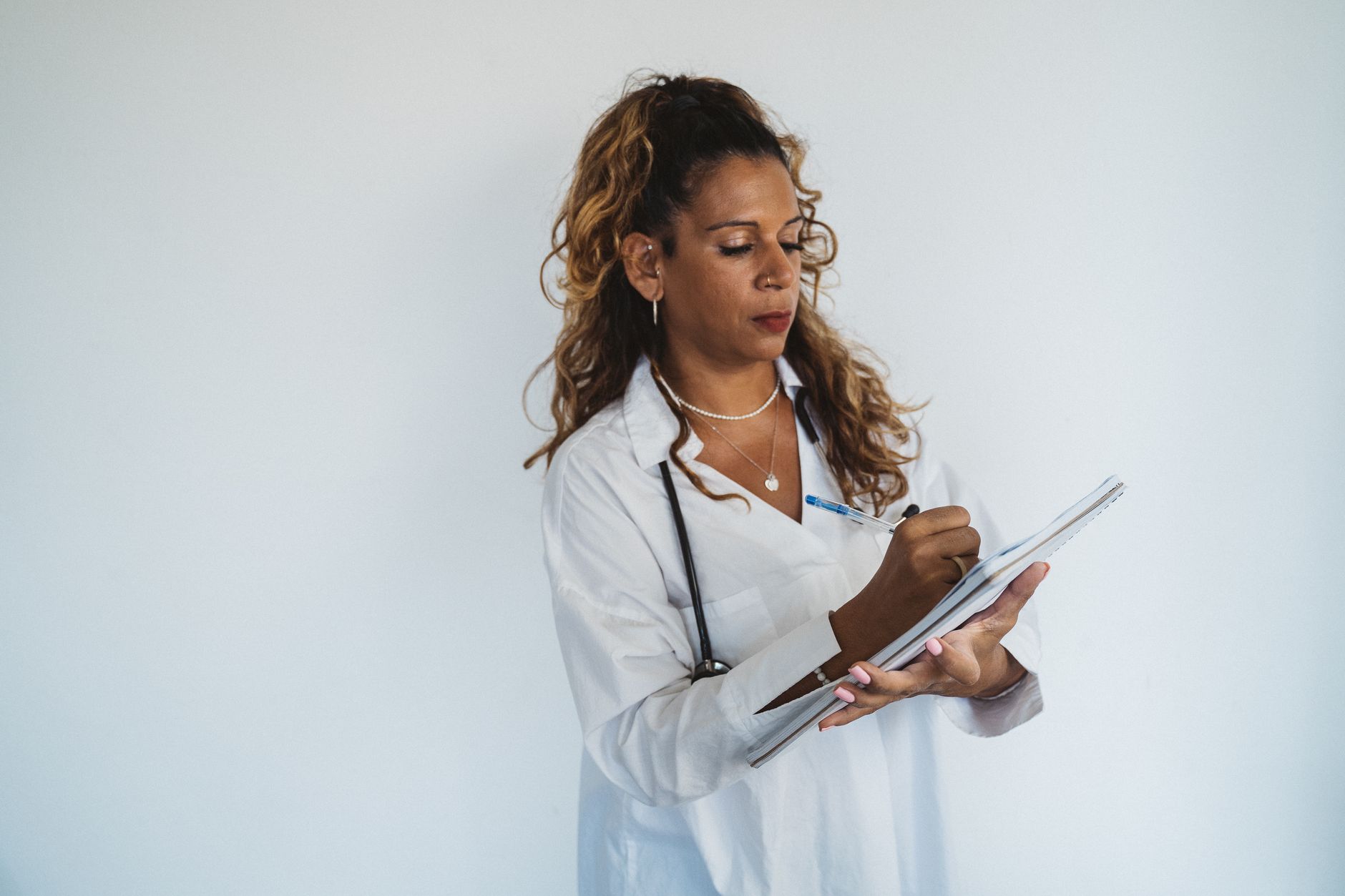 A clinician writing notes during a health appointment