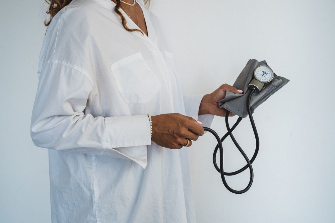Healthcare professional holding a blood pressure monitor during a wellness check