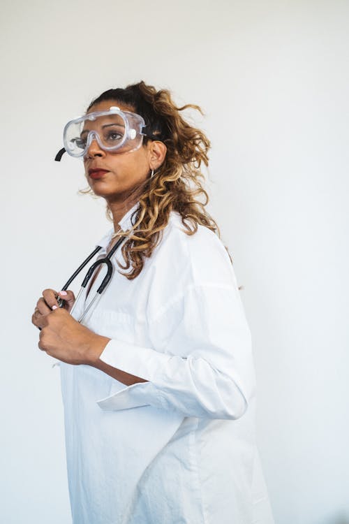Woman in White Medical Gown Wearing Eye Protector