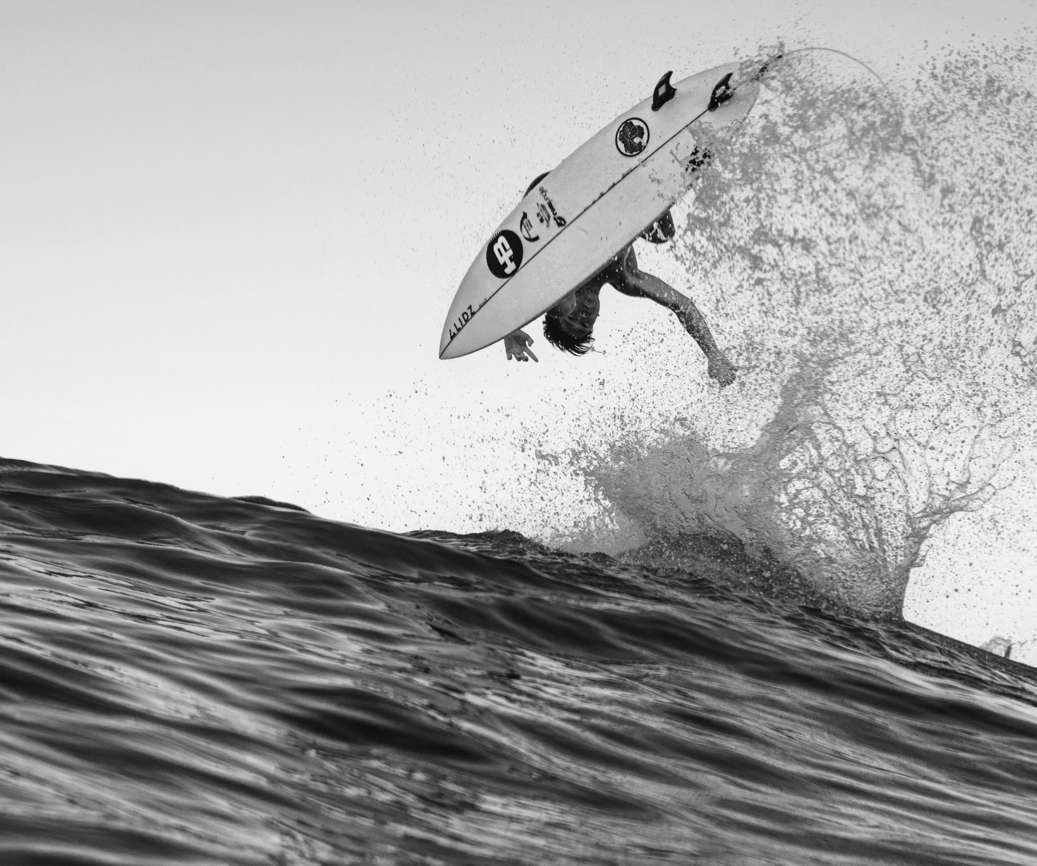 Surfer executes a high-flying trick on a wave in Miyazaki, Japan. Capturing the thrill of surfing.