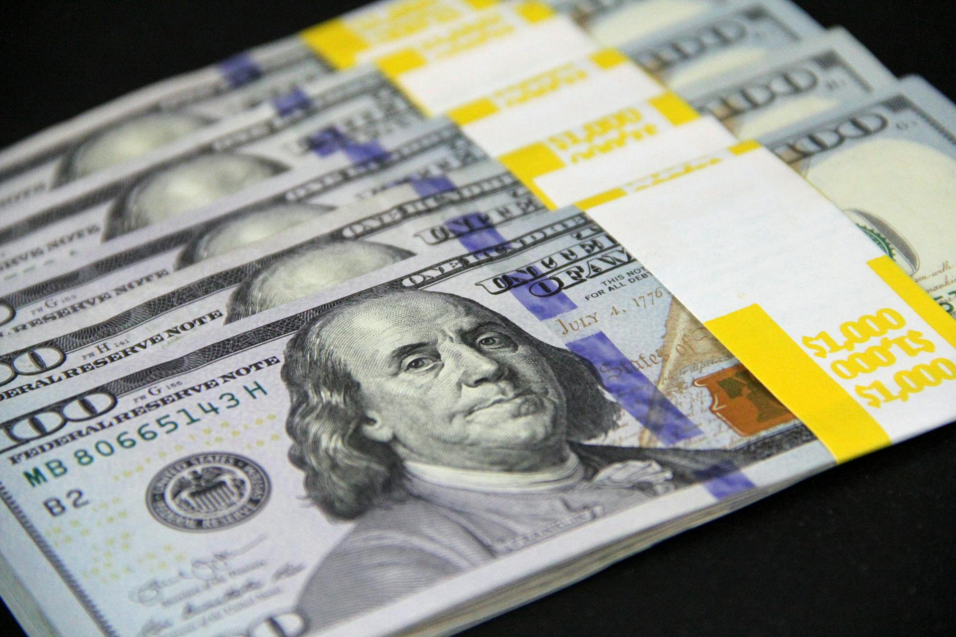 Close-up view of a stack of US hundred dollar bills representing finance and wealth.