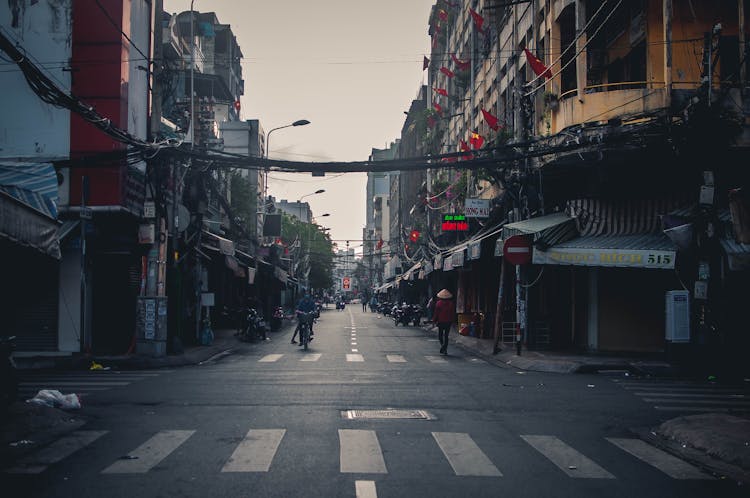 People Walking On Empty Street In City