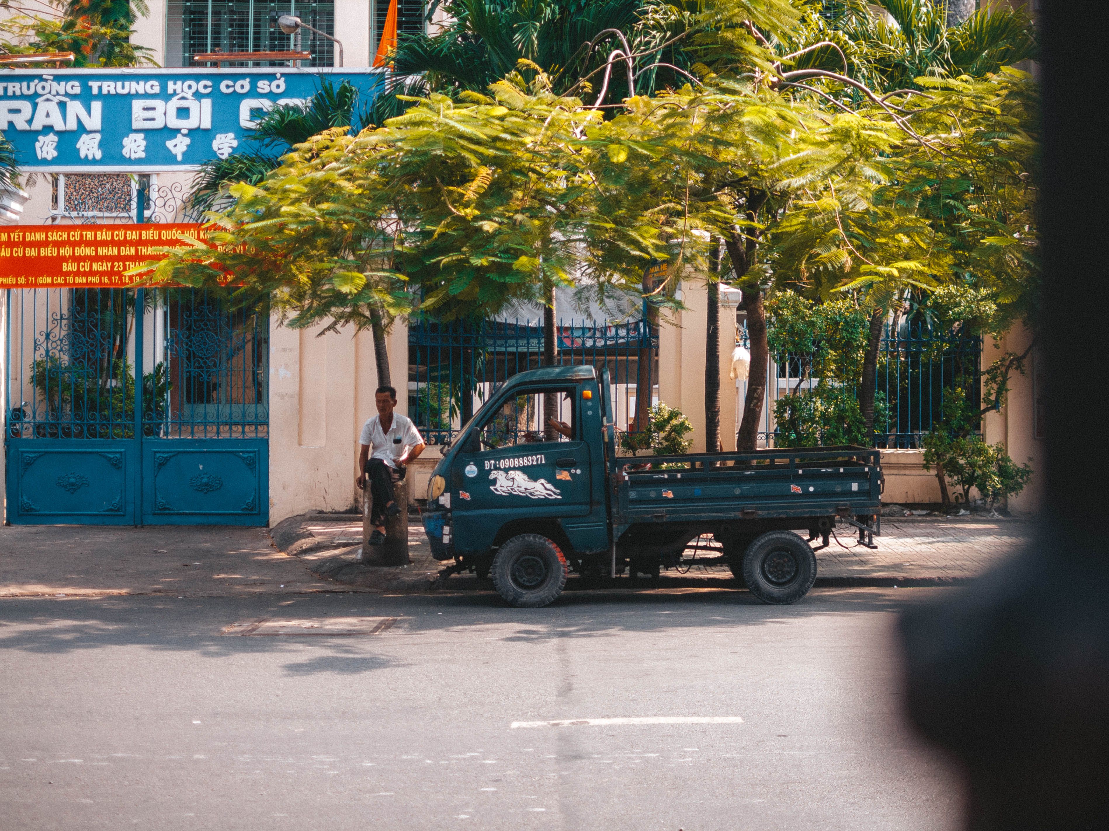 Outdoor street view in Ho Chi Minh City featuring a parked truck and greenery.