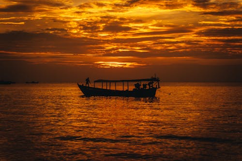 Silhouette of Boat on Sea During Sunset