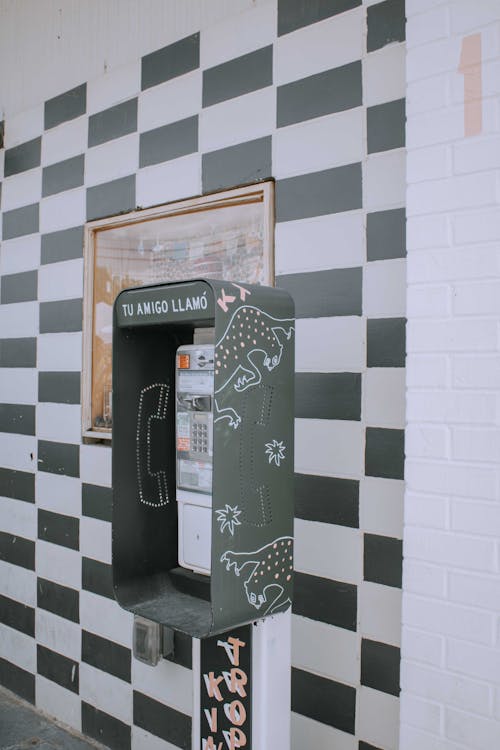 Free Payphone Beside a Tiled Wall Stock Photo