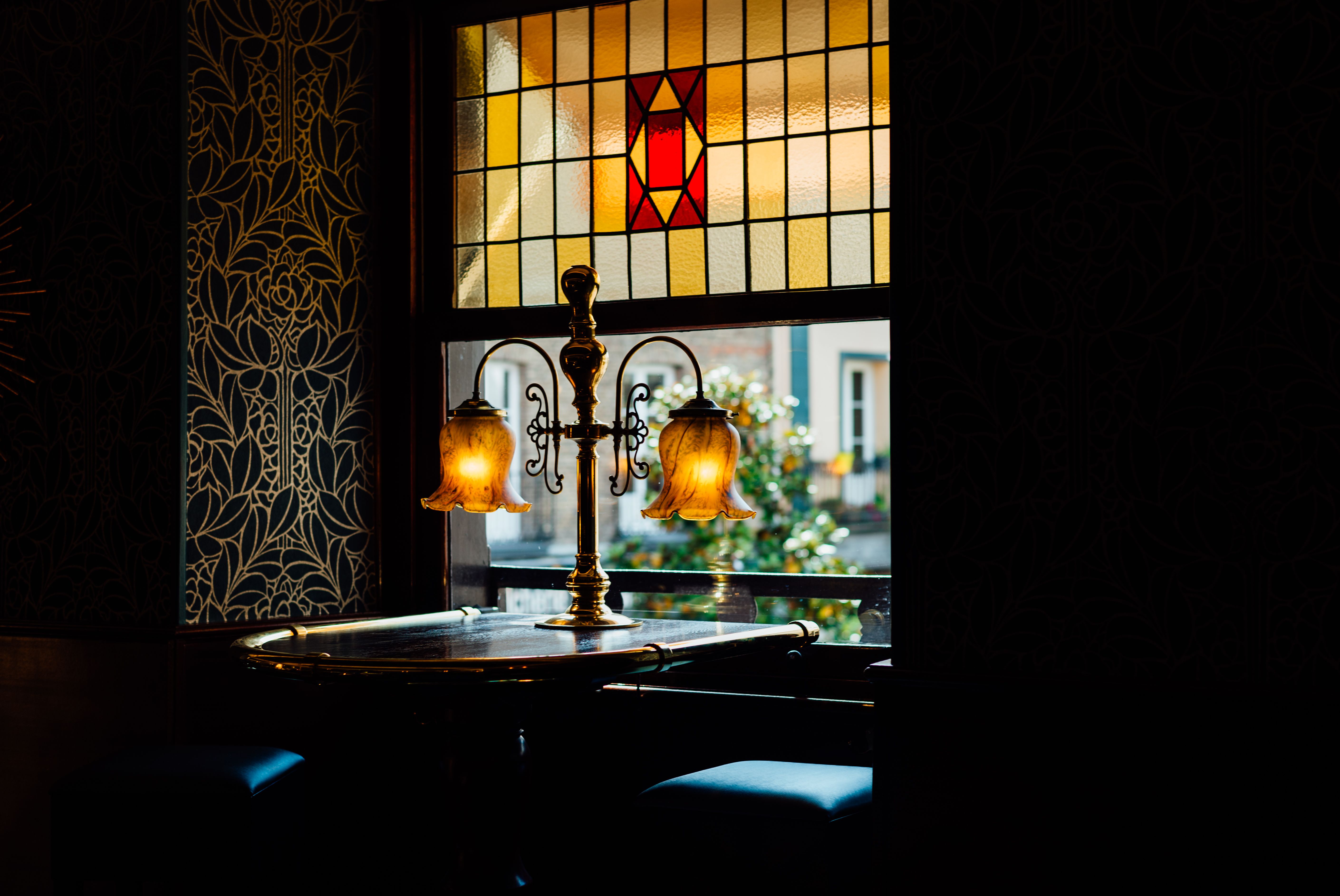 Charming café interior in Dieppe, France, featuring stained glass and vintage lighting.