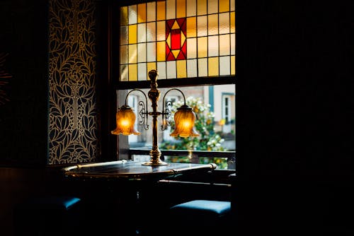 Free A Desk Lamp Near a Stained Glass Window Stock Photo