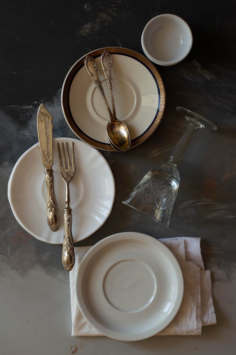 Gold Cutlery On Porcelain Plates