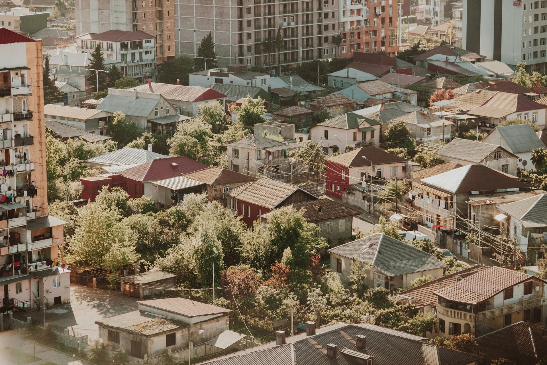 Aerial shot of urban residential area with diverse rooftops and greenery.