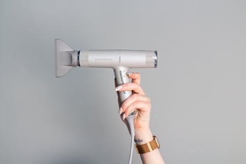 Close-Up Shot of a Person Holding a Blow Dryer