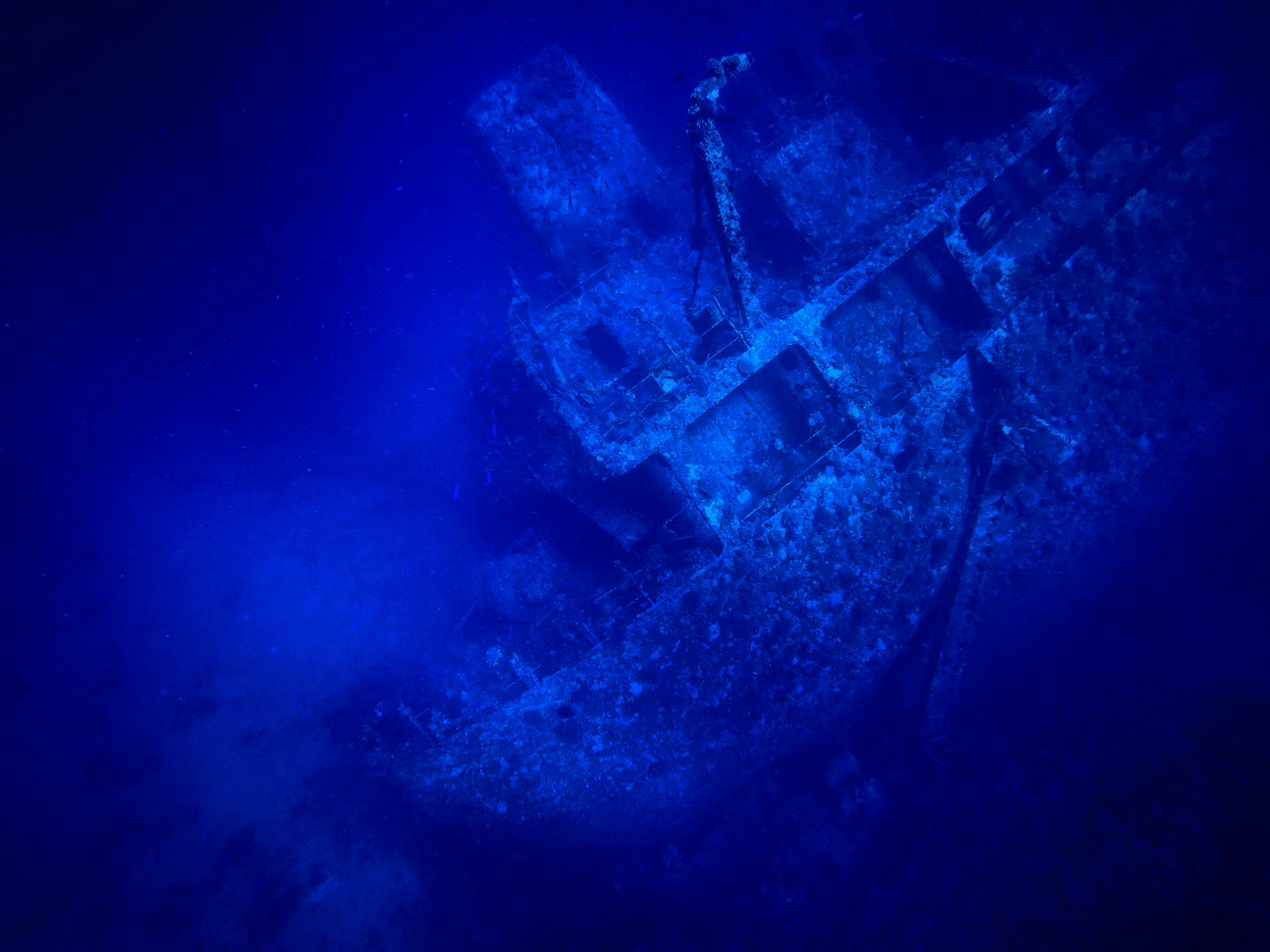 Discover the mysterious allure of a deep sea shipwreck in this striking underwater shot.