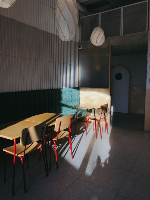 A stylish café interior in Minsk with chic furniture and dramatic sunlight streaming in.