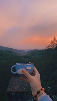 A calming moment enjoying tea at sunset with a scenic mountain backdrop.