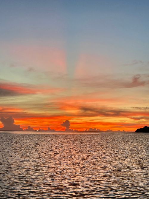 Free Breathtaking sunset over the ocean with vibrant colors and serene water reflections. Stock Photo