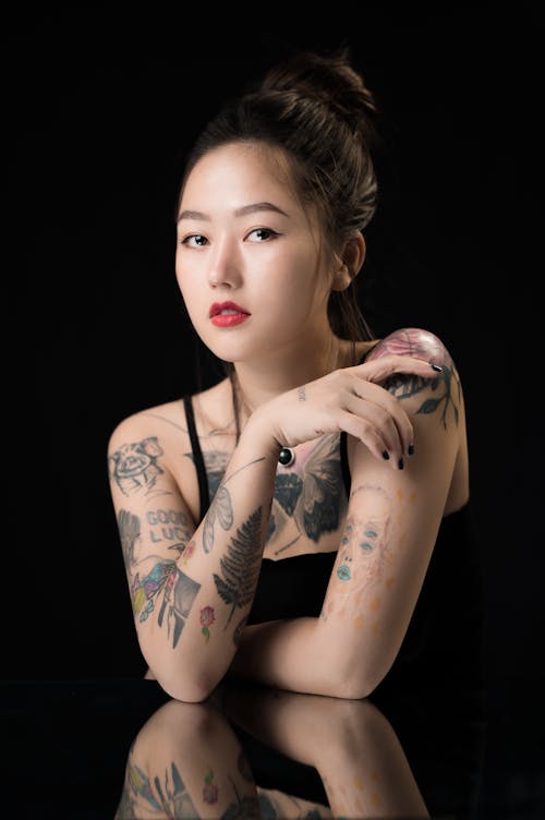 Free Photo of a Woman in a Black Tank Top with Tattoos on Her Body Stock Photo