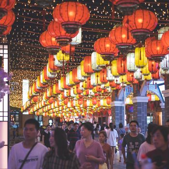 Bustling night market illuminated by colorful Chinese lanterns, bustling with people.（イメージ）