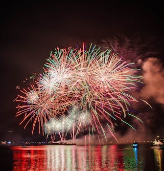 五彩缤纷的烟花在宁静的水面上空绽放，营造出节日的氛围