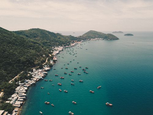 Free Stunning aerial view of Kien Giang's scenic coastline with vibrant boats and lush hills. Stock Photo
