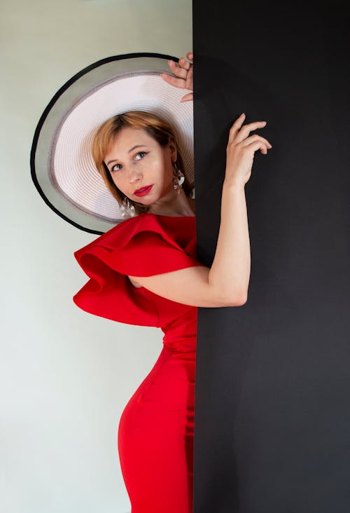 A Female Model in a Red Dress and a Big Hat