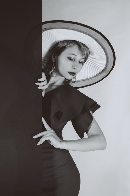 Free A sophisticated woman in a wide-brimmed hat, captured in a classic monochrome style. Stock Photo