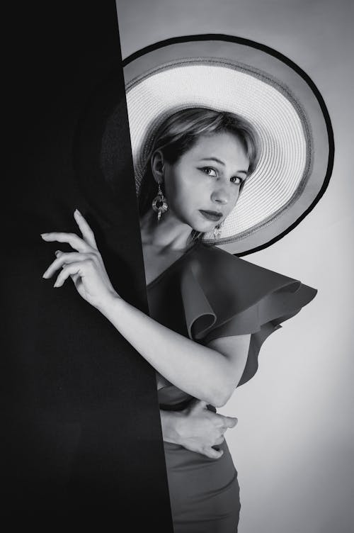 A Female Model Posing while Wearing a Big Hat and a Dress 