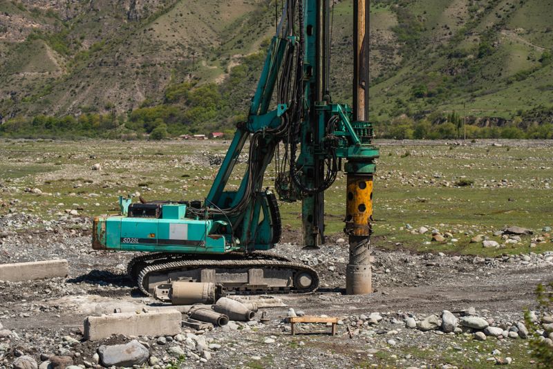 A heavy drilling machine in use on a rugged outdoor construction site