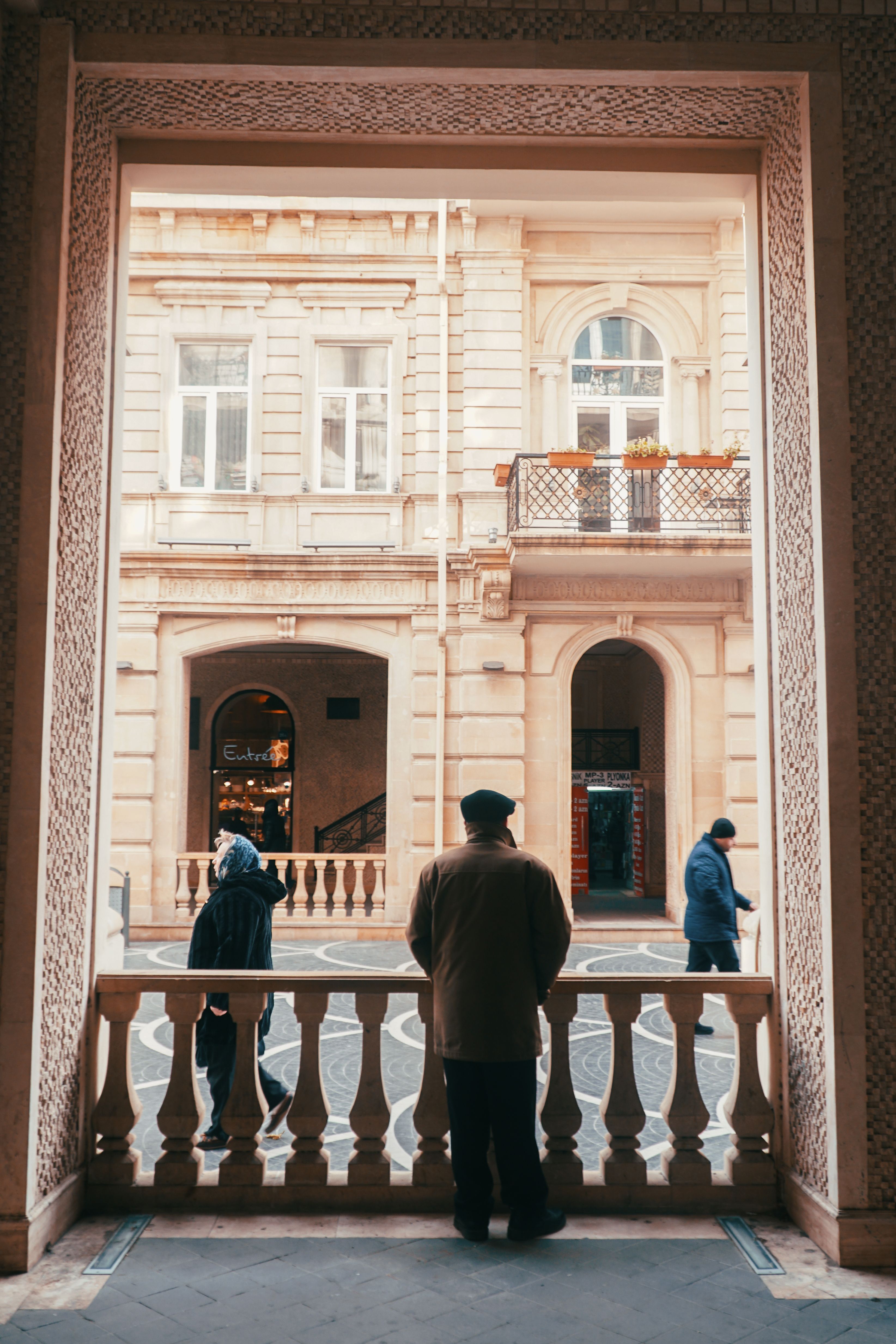 A Man Standing and Waiting Behind a Railing · Free Stock Photo