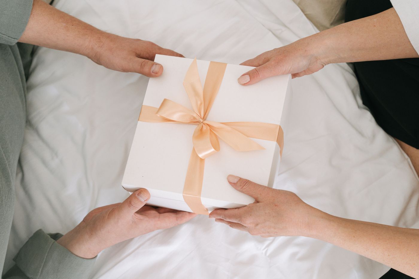 Two people exchanging a wrapped gift for a special occasion