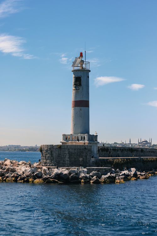 Free Lighthouse on rocky pier overlooking the sea in Istanbul on a sunny day. Stock Photo