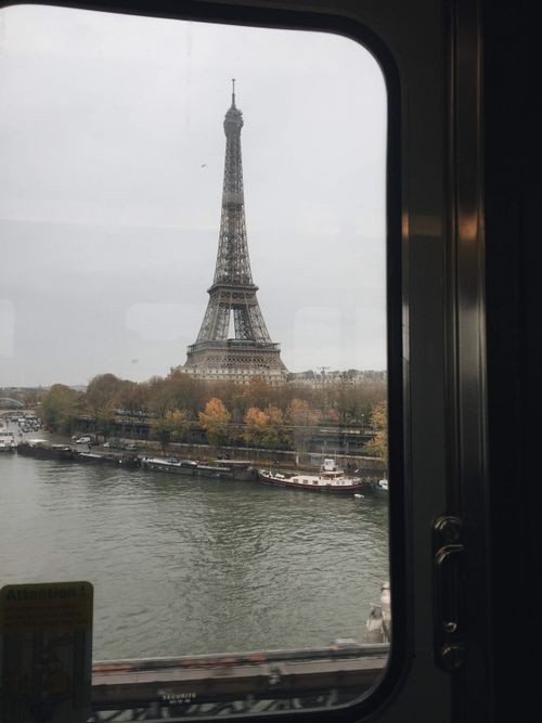 Free Scenic view of the Eiffel Tower from a train window, capturing Parisian charm and the Seine River. Stock Photo
