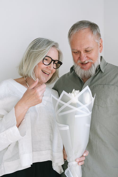 Free Man and Woman Looking at a Bouquet of Flowers Stock Photo