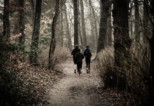 Monochrome Photography of People Jogging Through The Woods