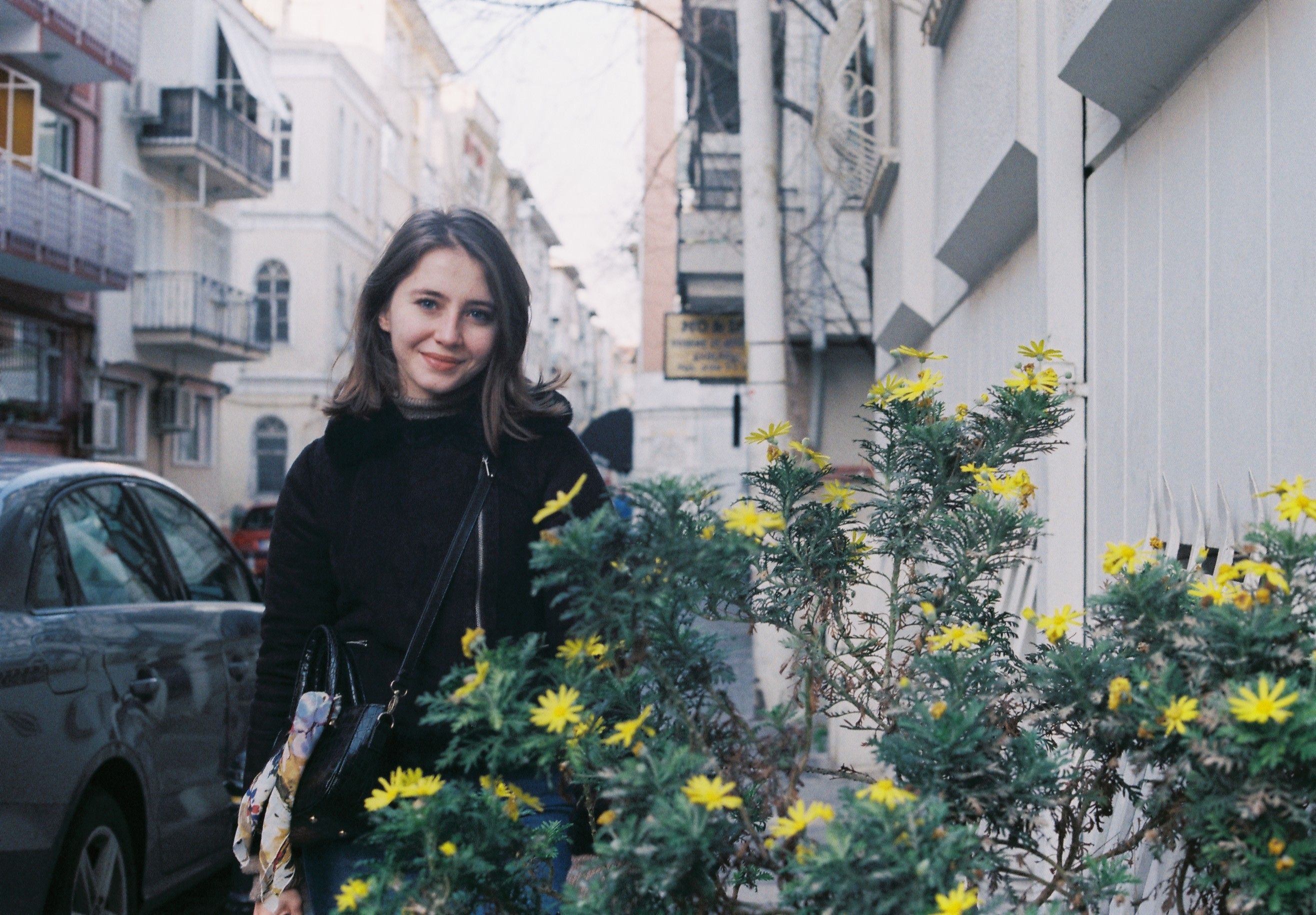 Woman in Black Jacket Standing Beside a Plant · Free Stock Photo