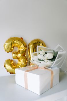 30th birthday celebration with balloons, tulip bouquet, and gift box.