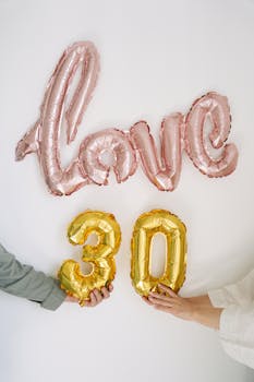 Pink and gold foil balloons spelling 'Love' and '30' for a birthday celebration.