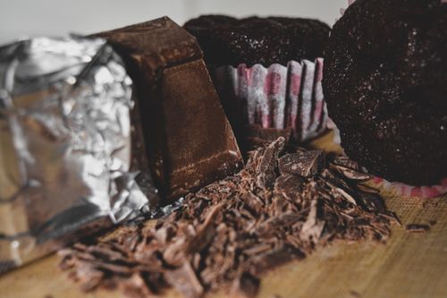 Free Delectable close-up of chocolate pieces, shavings, and muffins, showcasing delicious dessert textures. Stock Photo