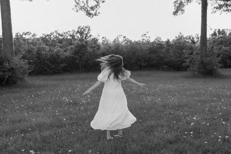 Anonymous Girl Spinning Around On Lawn