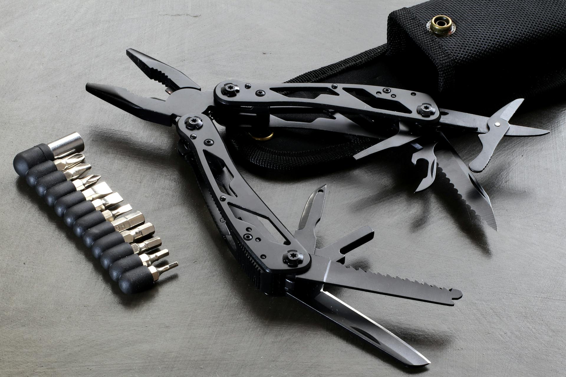 Black multi-tool with attachments displayed on a table, perfect for everyday needs.