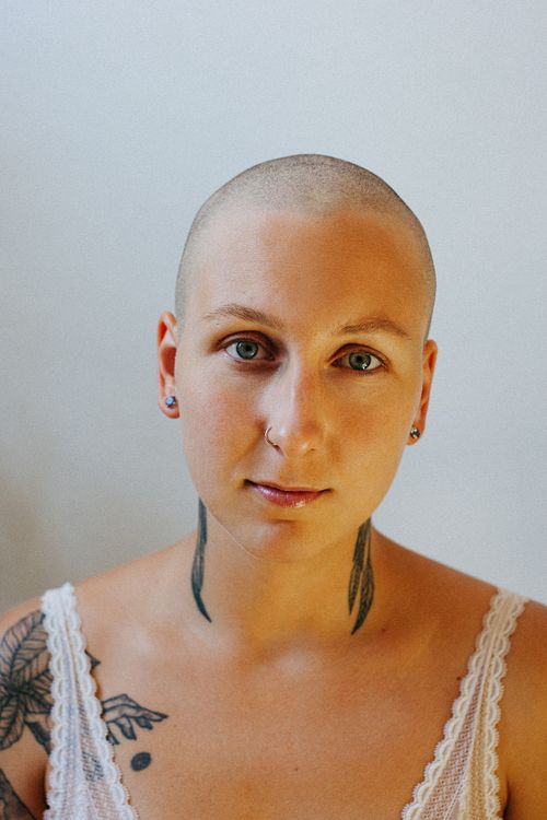 Free Bald woman with tattoos photographed in a close-up portrait, showcasing individuality. Stock Photo