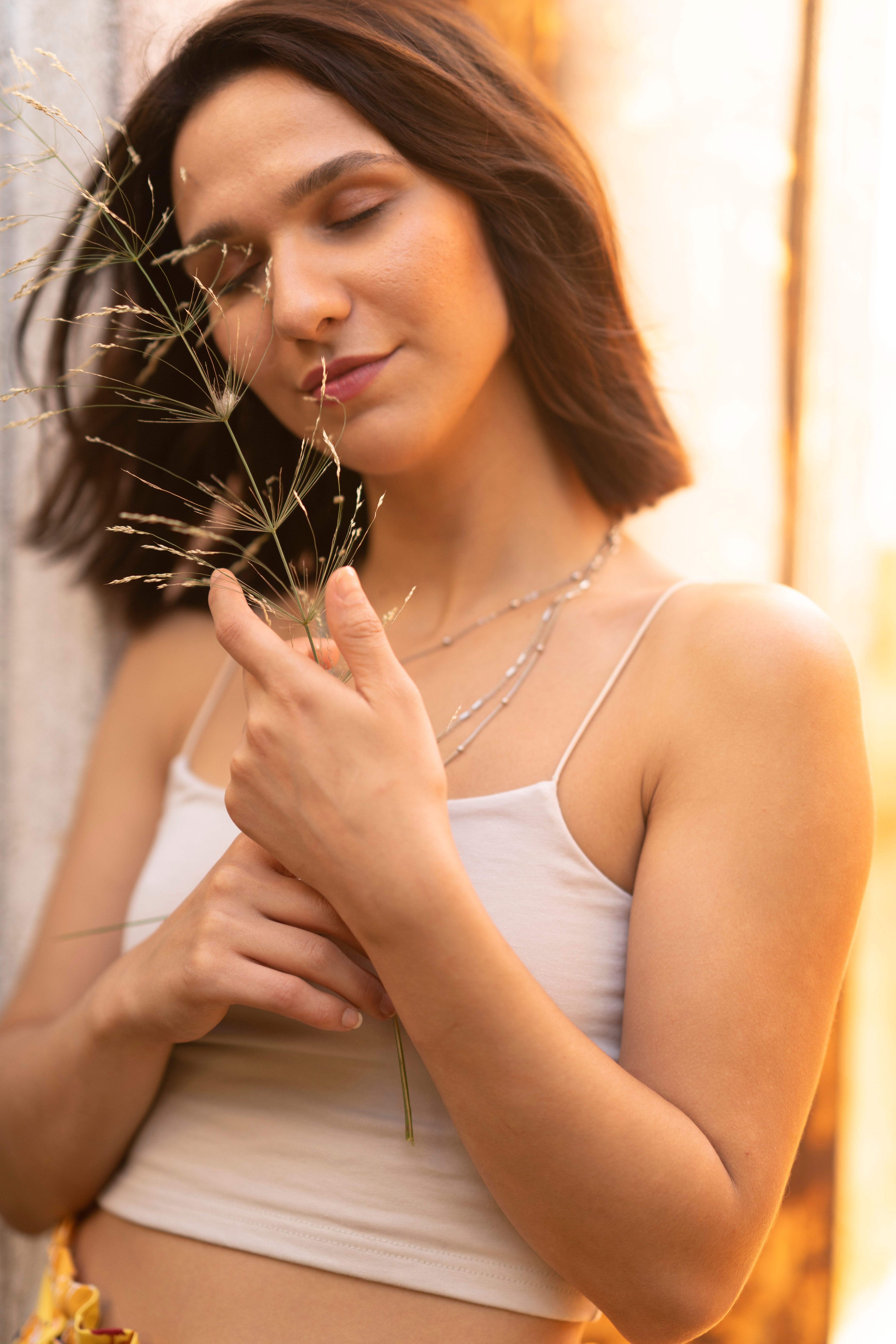 Woman in White Tank Top Holding Green Plant · Free Stock Photo
