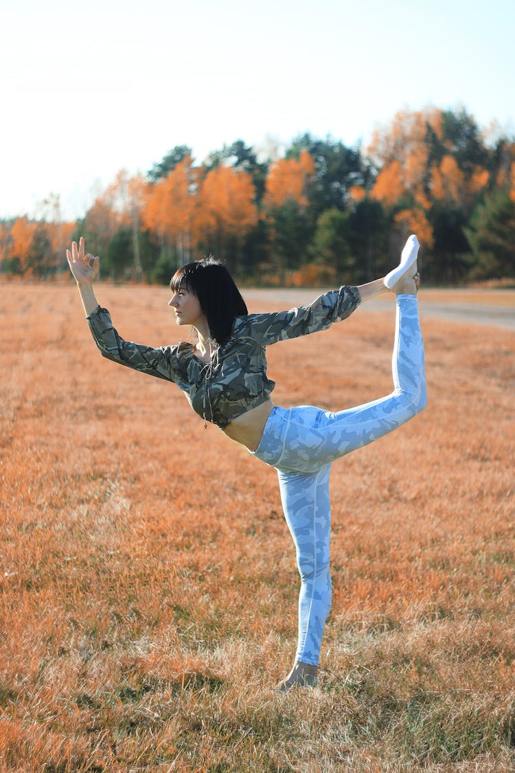 Young Woman Doing Yoga In Field