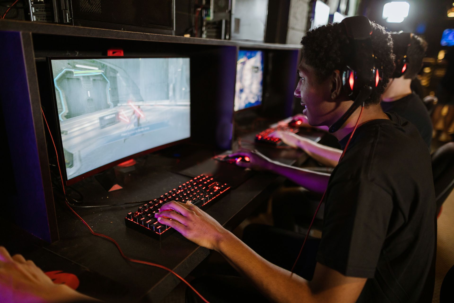 Focused gamers playing on high-performance computers in a cyber cafe. Capturing the intensity of an online gaming session.