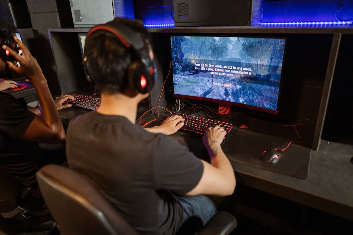 Helldivers 2 Devs Are Building A New Game, And They're Calling All The Shots 2 A person holding a black video game controller with colorful RGB lighting in the background.