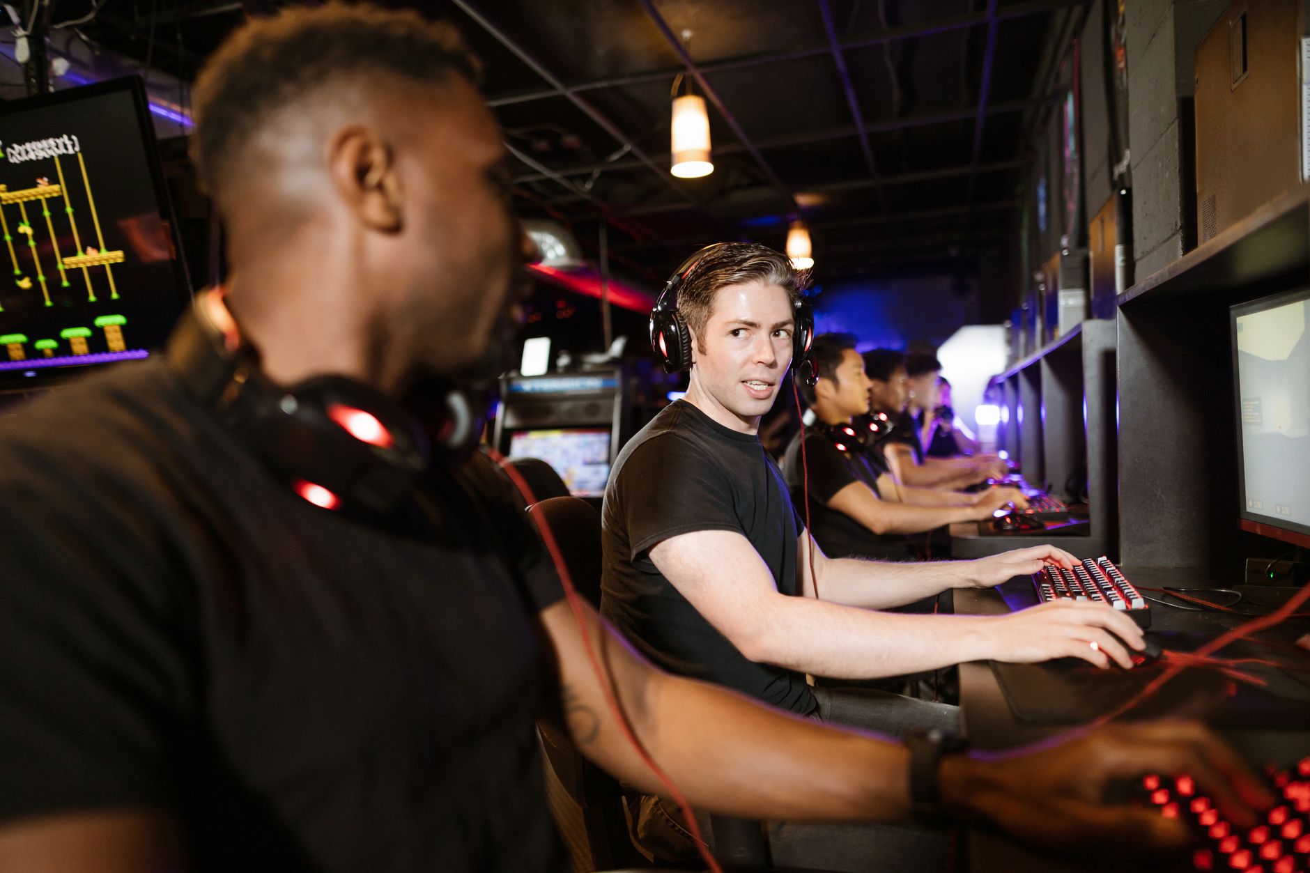 Group of friends playing video games at a cybercafe, enjoying an evening of esports.