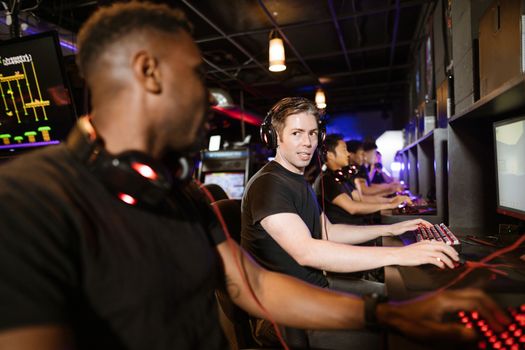 Group of friends playing video games at a cybercafe, enjoying an evening of esports.